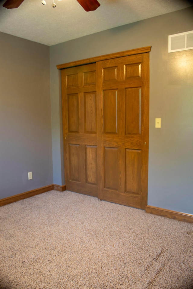 350 S Houston Pike, South Vienna, OH 45369 - unfurnished bedroom featuring carpet, baseboards, a closet, and ceiling fan