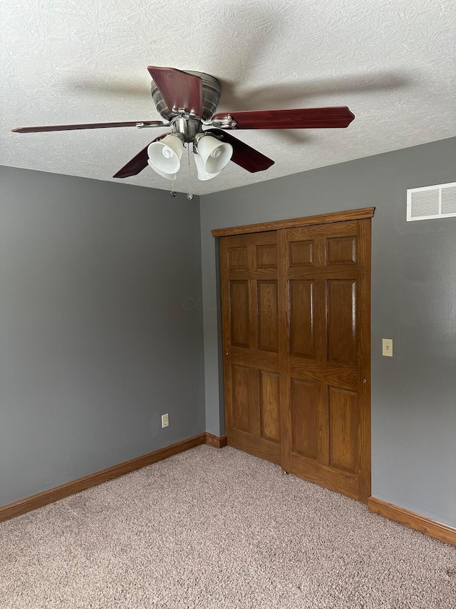 350 S Houston Pike, South Vienna, OH 45369 - unfurnished bedroom featuring light colored carpet, baseboards, a textured ceiling, a ceiling fan, and a closet