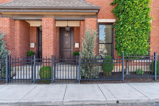 48 E 4th Ave, Columbus, OH 43201 - doorway to property with brick siding, roof with shingles, and a gate
