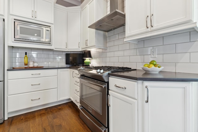 48 E 4th Ave, Columbus, OH 43201 - kitchen featuring wall chimney exhaust hood, appliances with stainless steel finishes, dark countertops, and white cabinets