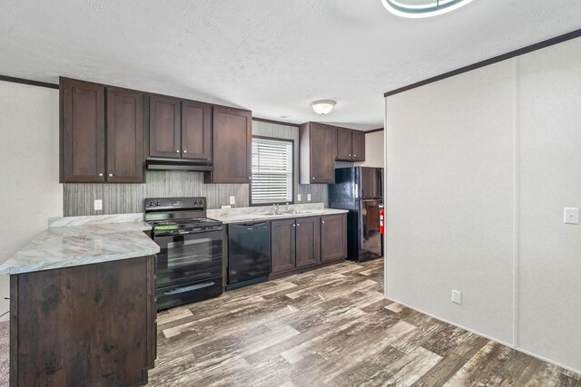 50 Winter Pine Dr, Delaware, OH 43015 - kitchen with black appliances, under cabinet range hood, a sink, a textured ceiling, and wood finished floors