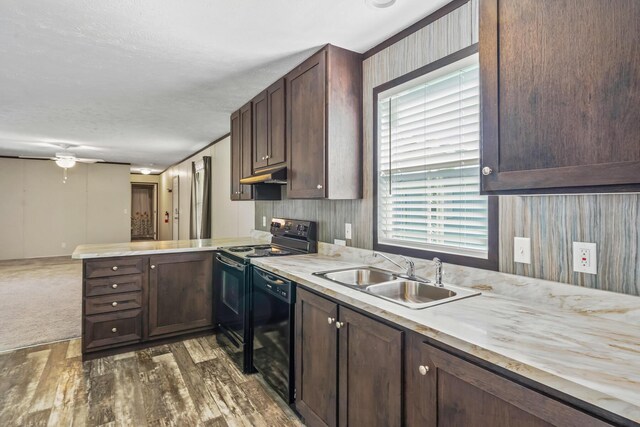 50 Winter Pine Dr, Delaware, OH 43015 - kitchen featuring a sink, black appliances, under cabinet range hood, light countertops, and a peninsula