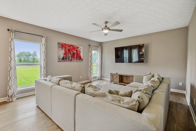 4483 County Road 124, Cardington, OH 43315 - living room with light wood-style flooring, ceiling fan, baseboards, and a textured ceiling