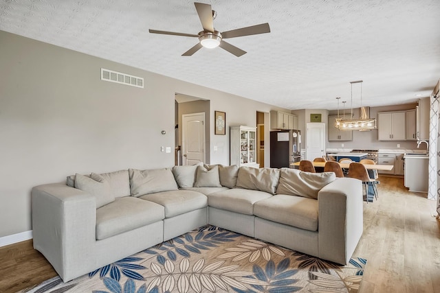 4483 County Road 124, Cardington, OH 43315 - living area featuring light wood-style floors, a ceiling fan, and a textured ceiling