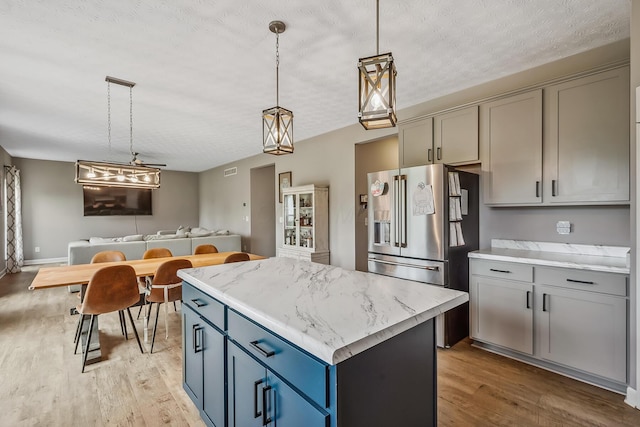 4483 County Road 124, Cardington, OH 43315 - kitchen with high end fridge, light wood-style floors, gray cabinetry, a center island, and a textured ceiling