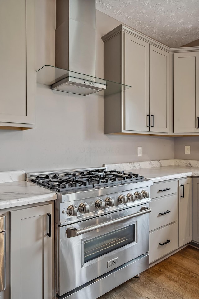 4483 County Road 124, Cardington, OH 43315 - kitchen featuring high end range, wall chimney exhaust hood, light wood-style flooring, and light stone countertops