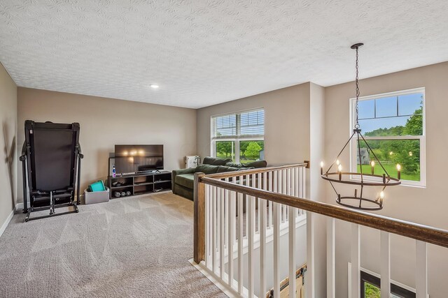 4483 County Road 124, Cardington, OH 43315 - hallway featuring carpet flooring, an upstairs landing, a chandelier, and a textured ceiling