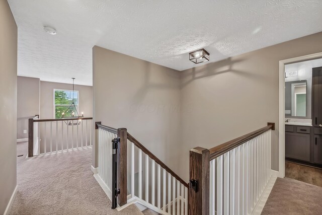 4483 County Road 124, Cardington, OH 43315 - hall featuring an upstairs landing, carpet, a textured ceiling, a sink, and baseboards