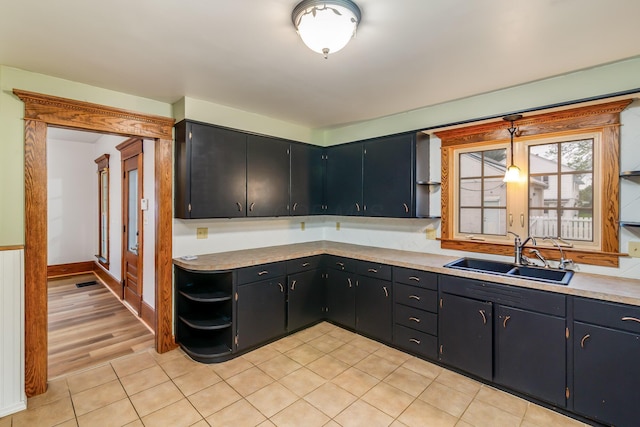 302 Oak St, Mount Vernon, OH 43050 - kitchen with a sink, open shelves, light countertops, dark cabinetry, and light tile patterned floors
