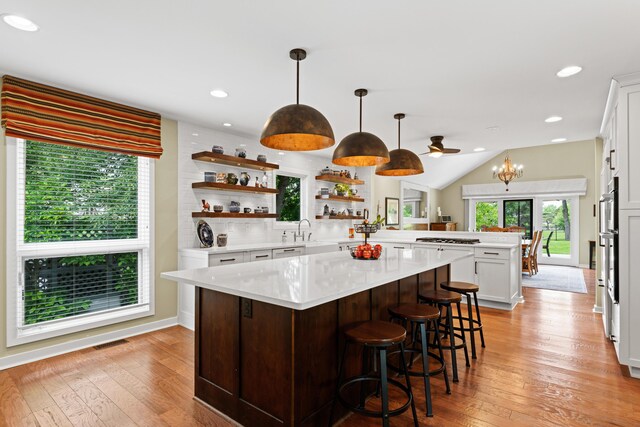 5518 Aryshire Ct, Dublin, OH 43017 - kitchen featuring a peninsula, open shelves, light countertops, white cabinetry, and light wood-style floors