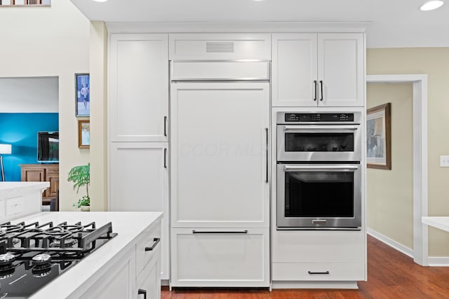5518 Aryshire Ct, Dublin, OH 43017 - kitchen with double oven, black gas stovetop, dark wood-style flooring, white cabinets, and baseboards