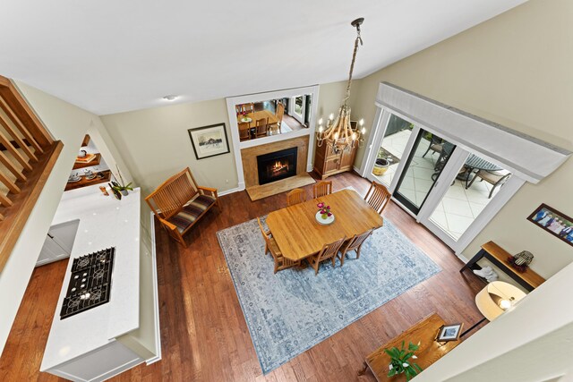 5518 Aryshire Ct, Dublin, OH 43017 - living room with a tiled fireplace, wood finished floors, a chandelier, baseboards, and stairway