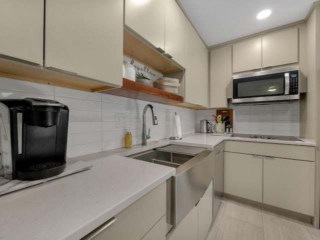 954 Circle Dr, Circleville, OH 43113 - kitchen with stainless steel microwave, black electric stovetop, decorative backsplash, light countertops, and open shelves