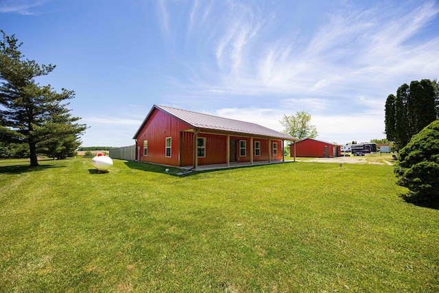 1674 Brock Rd NE, Bloomingburg, OH 43106 - rear view of property featuring a yard, metal roof, driveway, and a garage