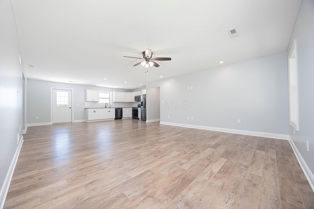 1674 Brock Rd NE, Bloomingburg, OH 43106 - unfurnished living room featuring a ceiling fan, light wood-style floors, baseboards, recessed lighting, and a sink