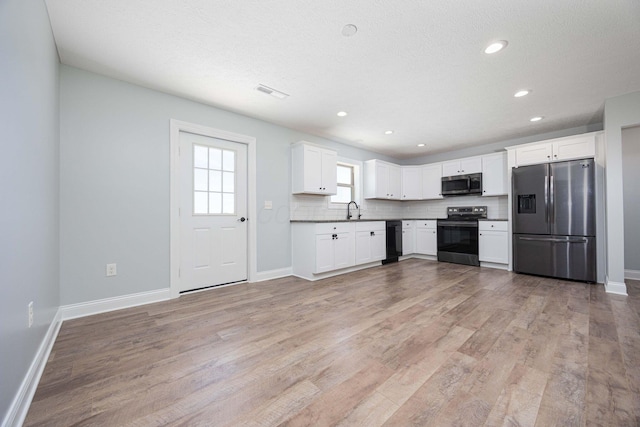 1674 Brock Rd NE, Bloomingburg, OH 43106 - kitchen featuring stainless steel appliances, light wood-style floors, baseboards, white cabinets, and tasteful backsplash