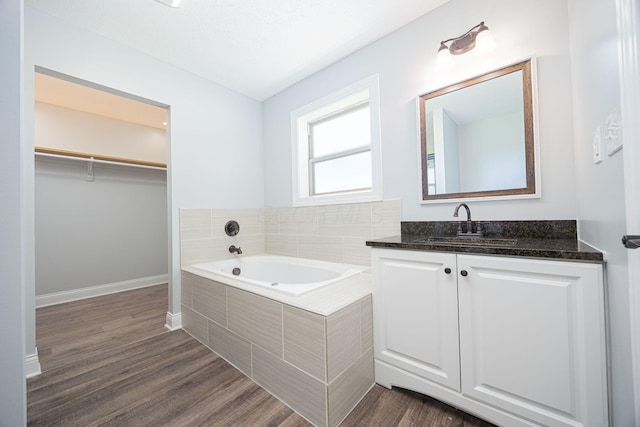 1674 Brock Rd NE, Bloomingburg, OH 43106 - bathroom featuring a bath, vanity, wood finished floors, baseboards, and a spacious closet