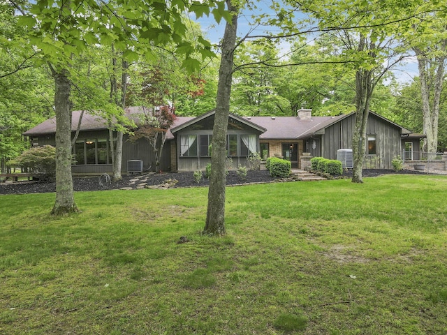 13115 Jack Run Rd, Rockbridge, OH 43149 - view of front of house featuring a front yard, a chimney, board and batten siding, and central air condition unit