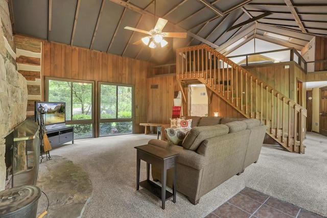 13115 Jack Run Rd, Rockbridge, OH 43149 - carpeted living area featuring vaulted ceiling, wood walls, a ceiling fan, tile patterned floors, and stairs