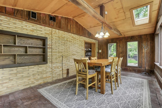 13115 Jack Run Rd, Rockbridge, OH 43149 - dining space with vaulted ceiling, a chandelier, a skylight, wood walls, and brick flooring