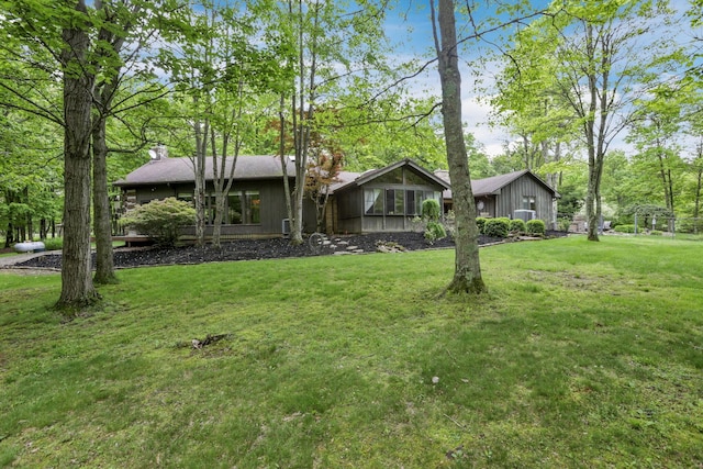 13115 Jack Run Rd, Rockbridge, OH 43149 - view of front of house with a front yard, a chimney, and board and batten siding