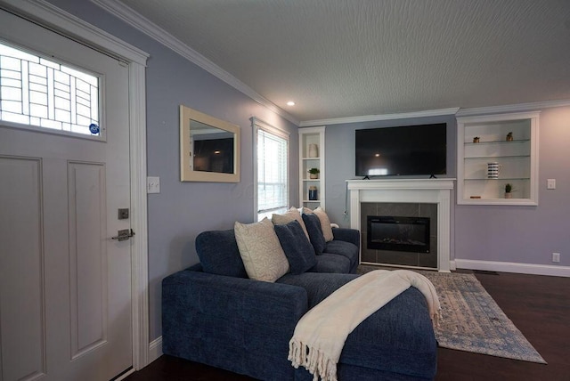 258 E Welch Ave, Columbus, OH 43207 - living room with a tiled fireplace, baseboards, crown molding, built in shelves, and dark wood-type flooring