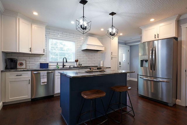 258 E Welch Ave, Columbus, OH 43207 - kitchen featuring stainless steel appliances, custom range hood, a sink, a kitchen island, and dark wood-style flooring