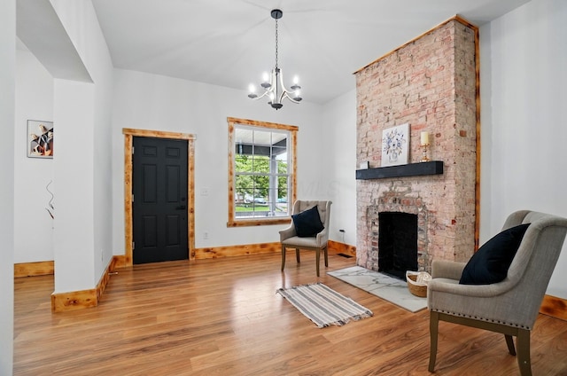 525 Saint Clair Ave, Columbus, OH 43203 - sitting room featuring wood finished floors, a chandelier, a large fireplace, and baseboards