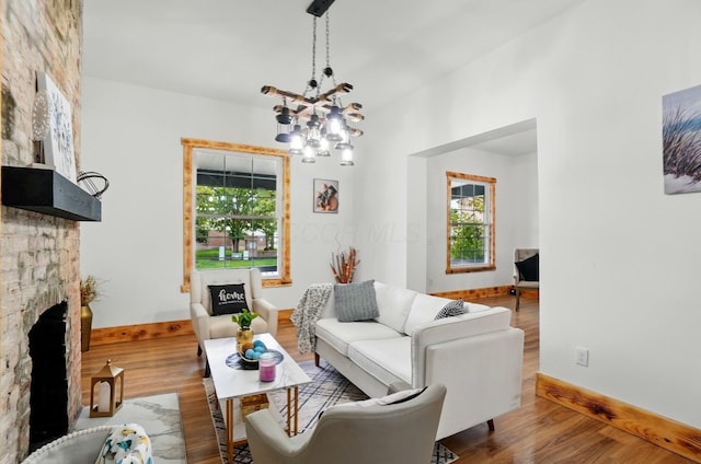 525 Saint Clair Ave, Columbus, OH 43203 - living room with a chandelier, wood finished floors, a fireplace, and baseboards