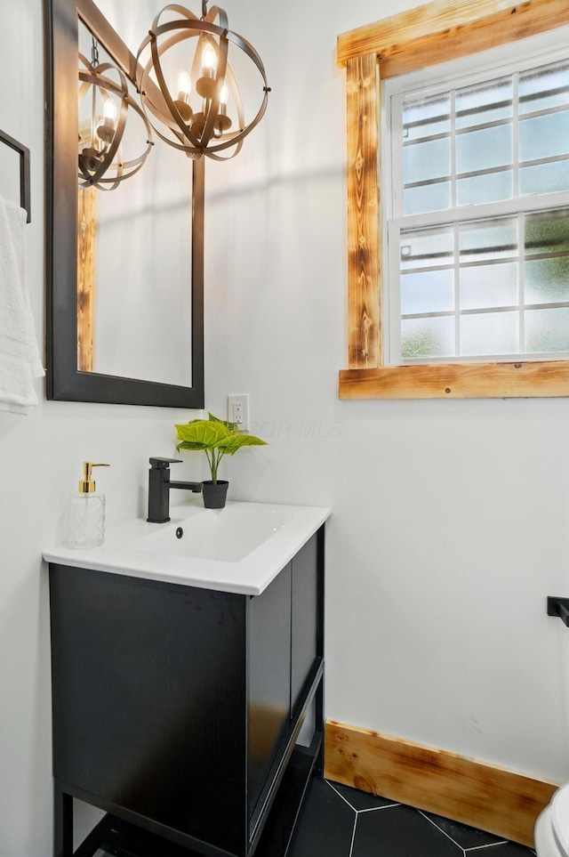 525 Saint Clair Ave, Columbus, OH 43203 - bathroom with a chandelier, vanity, tile patterned floors, toilet, and baseboards