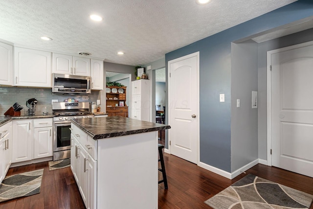 6407 Skywae Dr, Columbus, OH 43229 - kitchen featuring stainless steel appliances, dark countertops, dark wood finished floors, a textured ceiling, and recessed lighting