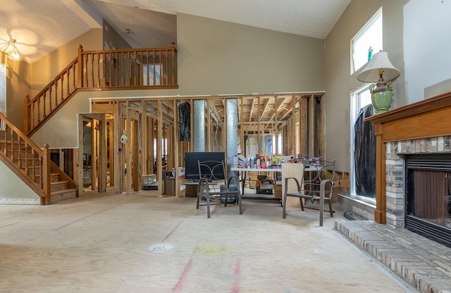 7711 Eagle Creek Dr, Pickerington, OH 43147 - living room featuring high vaulted ceiling, stairs, and a brick fireplace