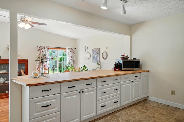 3784 Hendron Rd, Groveport, OH 43125 - kitchen featuring wood counters, stainless steel microwave, ceiling fan, white cabinets, and a textured ceiling
