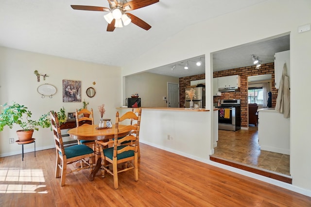 3784 Hendron Rd, Groveport, OH 43125 - dining area featuring a ceiling fan, brick wall, light wood-type flooring, baseboards, and a brick fireplace