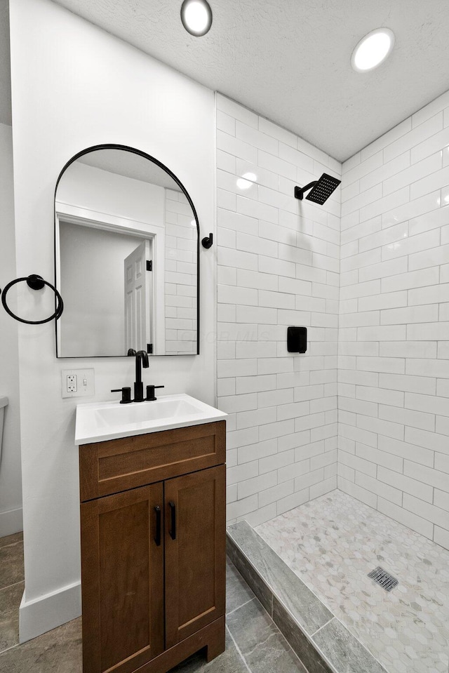 1006 Midland Ave, Columbus, OH 43223 - full bath featuring vanity, a tile shower, baseboards, recessed lighting, and a textured ceiling