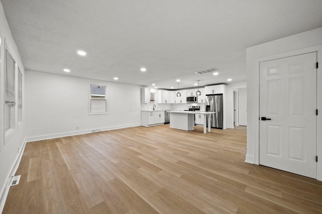 1006 Midland Ave, Columbus, OH 43223 - unfurnished living room featuring recessed lighting, light wood finished floors, baseboards, and a sink