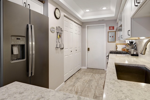 2539 Trotterslane Dr, Columbus, OH 43235 - kitchen featuring stainless steel fridge with ice dispenser, a sink, white cabinets, light stone countertops, and a raised ceiling