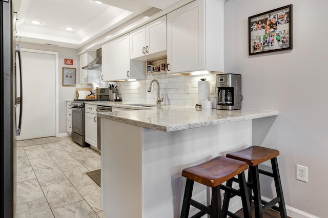 2539 Trotterslane Dr, Columbus, OH 43235 - kitchen with appliances with stainless steel finishes, a sink, a peninsula, wall chimney exhaust hood, and white cabinets