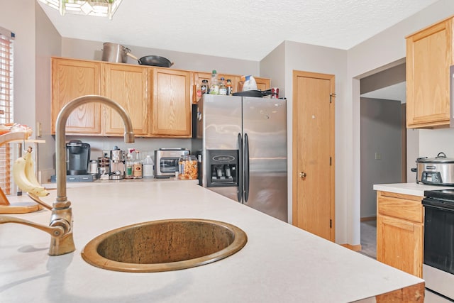 3150 Berkley Pointe Dr, Gahanna, OH 43230 - kitchen featuring stainless steel fridge with ice dispenser, light brown cabinets, a sink, light countertops, and range