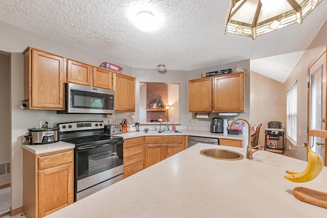 3150 Berkley Pointe Dr, Gahanna, OH 43230 - kitchen with appliances with stainless steel finishes, light countertops, a sink, a textured ceiling, and lofted ceiling