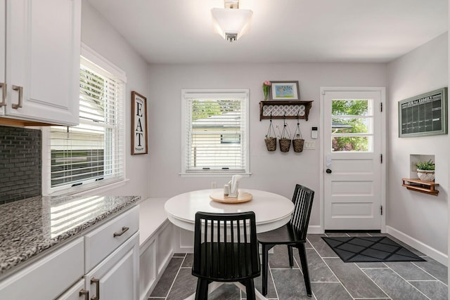 2380 Cranford Rd, Upper Arlington, OH 43221 - dining space with plenty of natural light, dark tile patterned flooring, baseboards, and a wall mounted AC