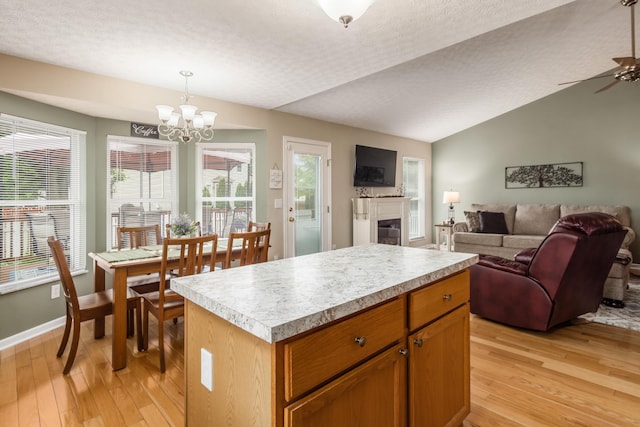 4989 Edgeley Dr, Hilliard, OH 43026 - kitchen with light wood finished floors, light countertops, open floor plan, a kitchen island, and vaulted ceiling