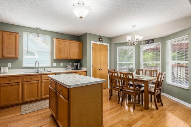 4989 Edgeley Dr, Hilliard, OH 43026 - kitchen with a sink, a textured ceiling, light wood-type flooring, light countertops, and a center island
