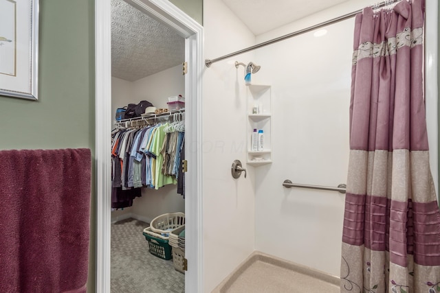 4989 Edgeley Dr, Hilliard, OH 43026 - bathroom featuring a shower with shower curtain, a textured ceiling, and a spacious closet