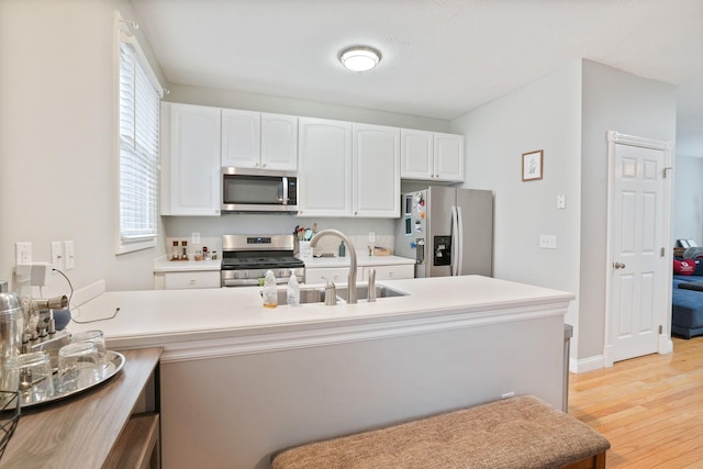 963 Delaware Ave, Columbus, OH 43201 - kitchen with stainless steel appliances, light wood-style flooring, white cabinetry, light countertops, and a sink