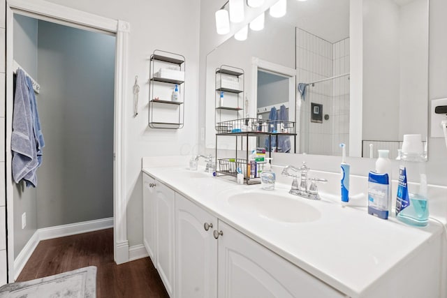 963 Delaware Ave, Columbus, OH 43201 - bathroom with wood finished floors, double vanity, tiled shower, and baseboards
