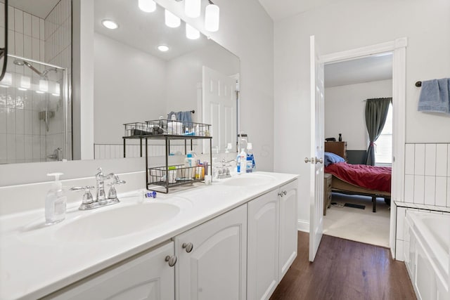 963 Delaware Ave, Columbus, OH 43201 - ensuite bathroom featuring double vanity, wood finished floors, a tile shower, and a tub