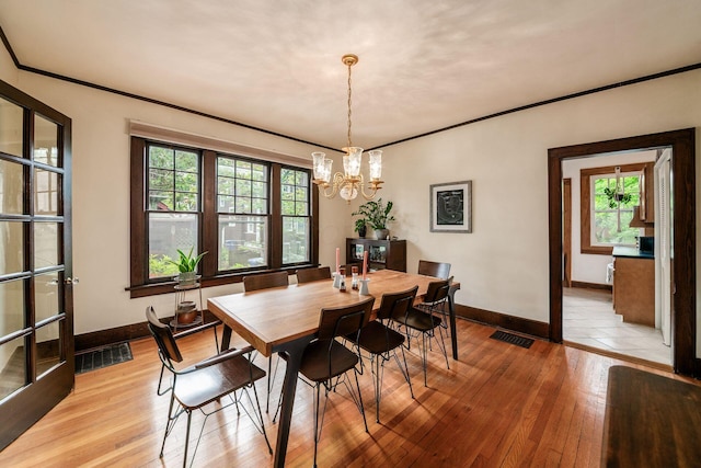 431 Glen Echo Cir, Columbus, OH 43202 - dining area featuring baseboards, a chandelier, light wood-style floors, and ornamental molding