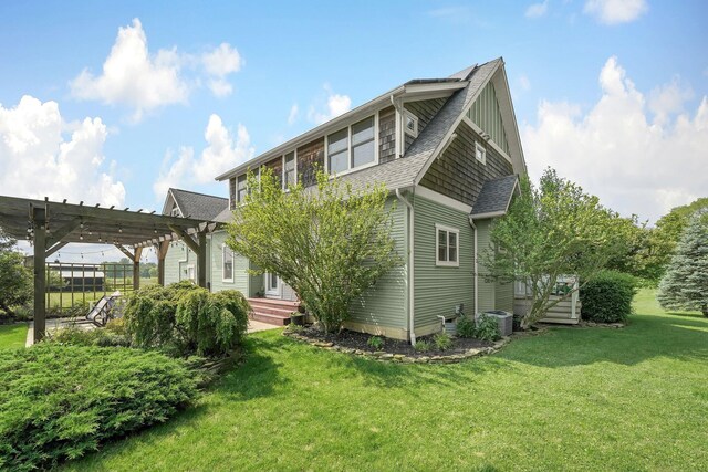 14980 Robins Rd, Johnstown, OH 43031 - view of side of home with a pergola, a yard, a shingled roof, and cooling unit