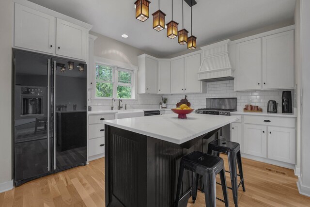14980 Robins Rd, Johnstown, OH 43031 - kitchen featuring black fridge with ice dispenser, premium range hood, white cabinetry, light countertops, and decorative backsplash